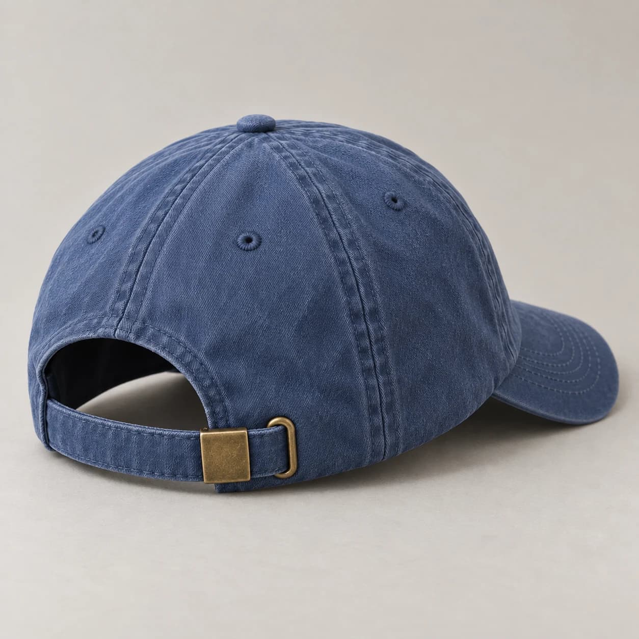 Illustrative rear view of a washed cap with a fabric strap and metal buckle