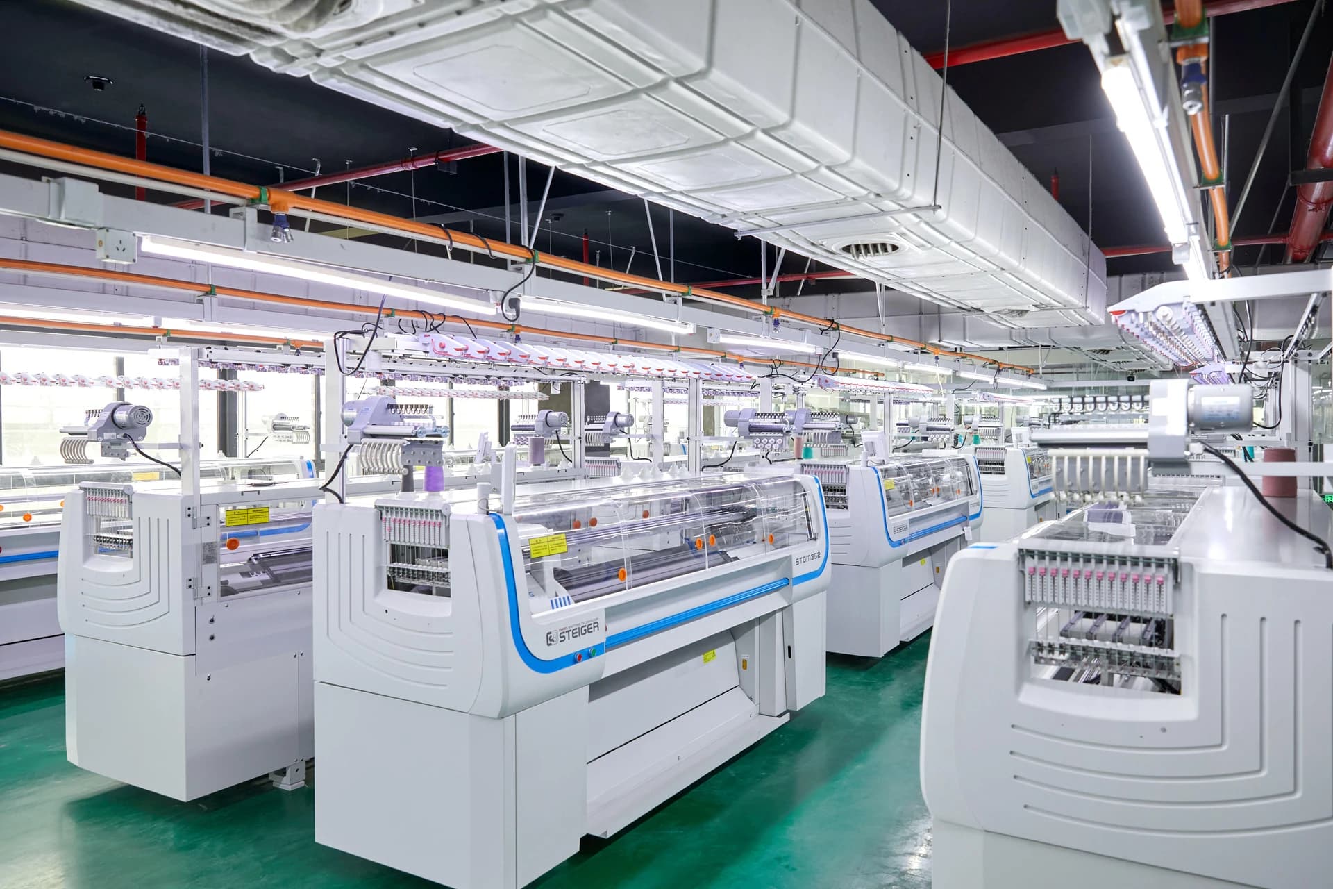 Rows of flat knitting machines in a workshop