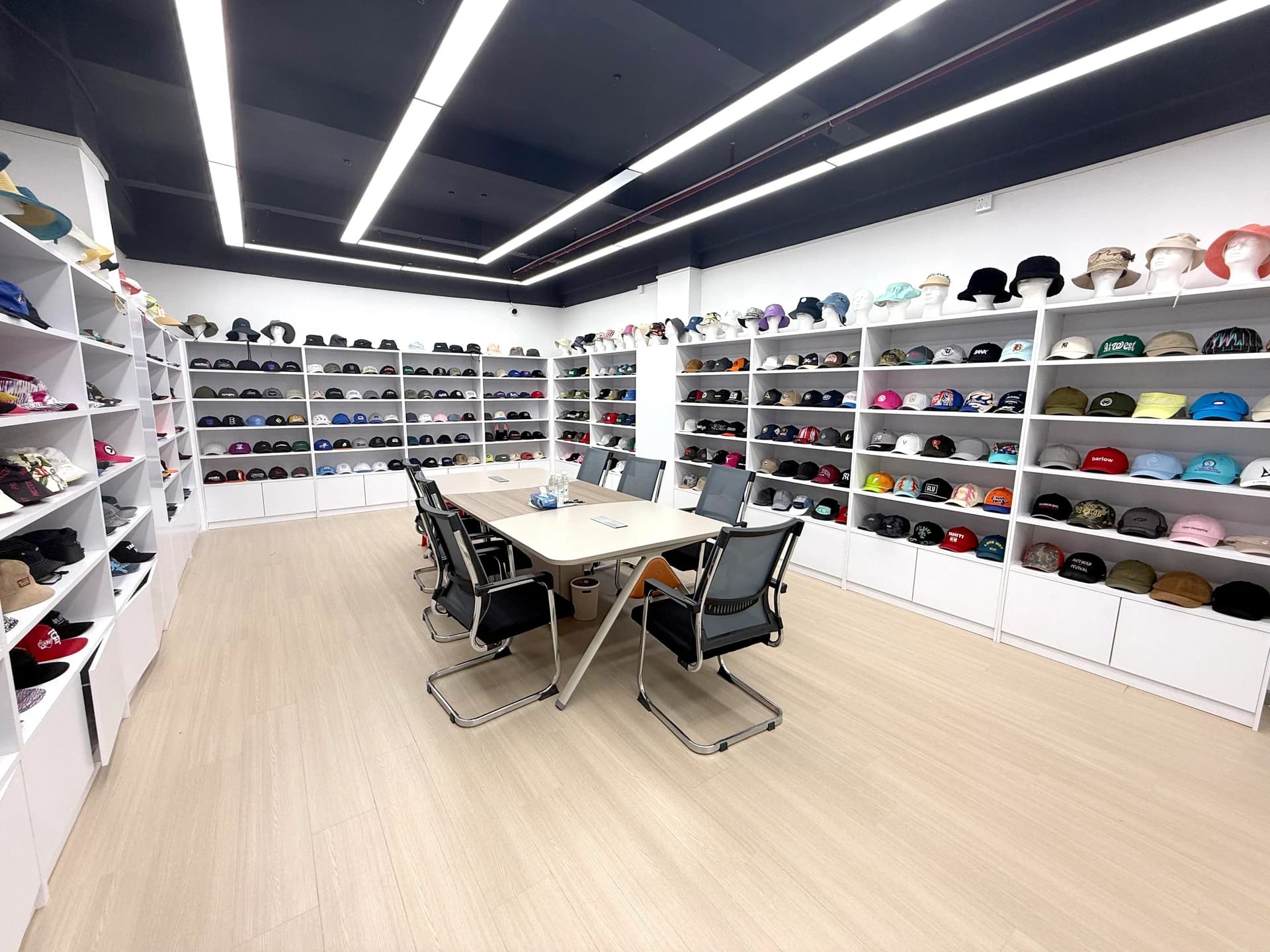 Headwear sample displays surrounding the factory discussion table