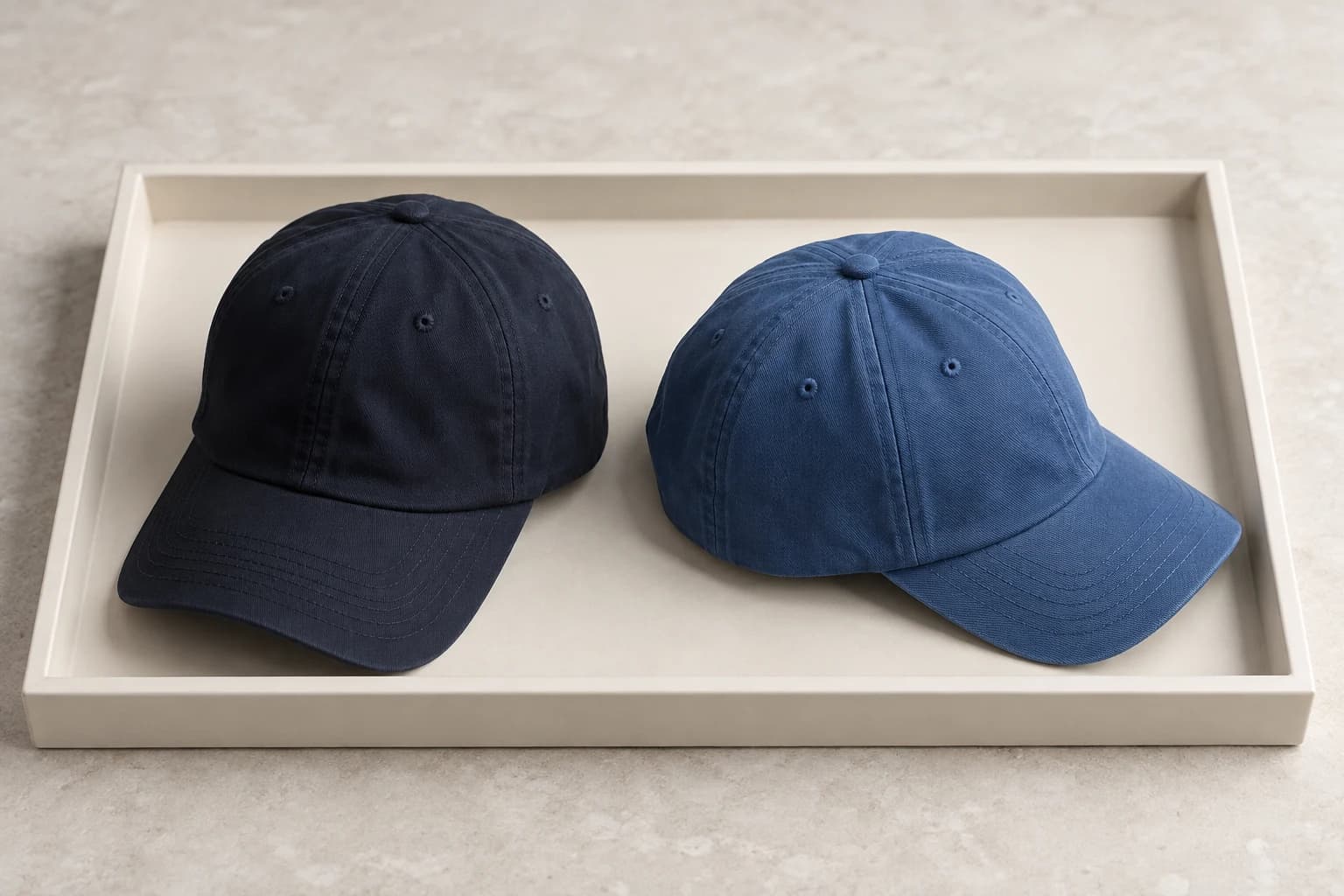 Illustration of one baseball cap silhouette in navy and blue colorways